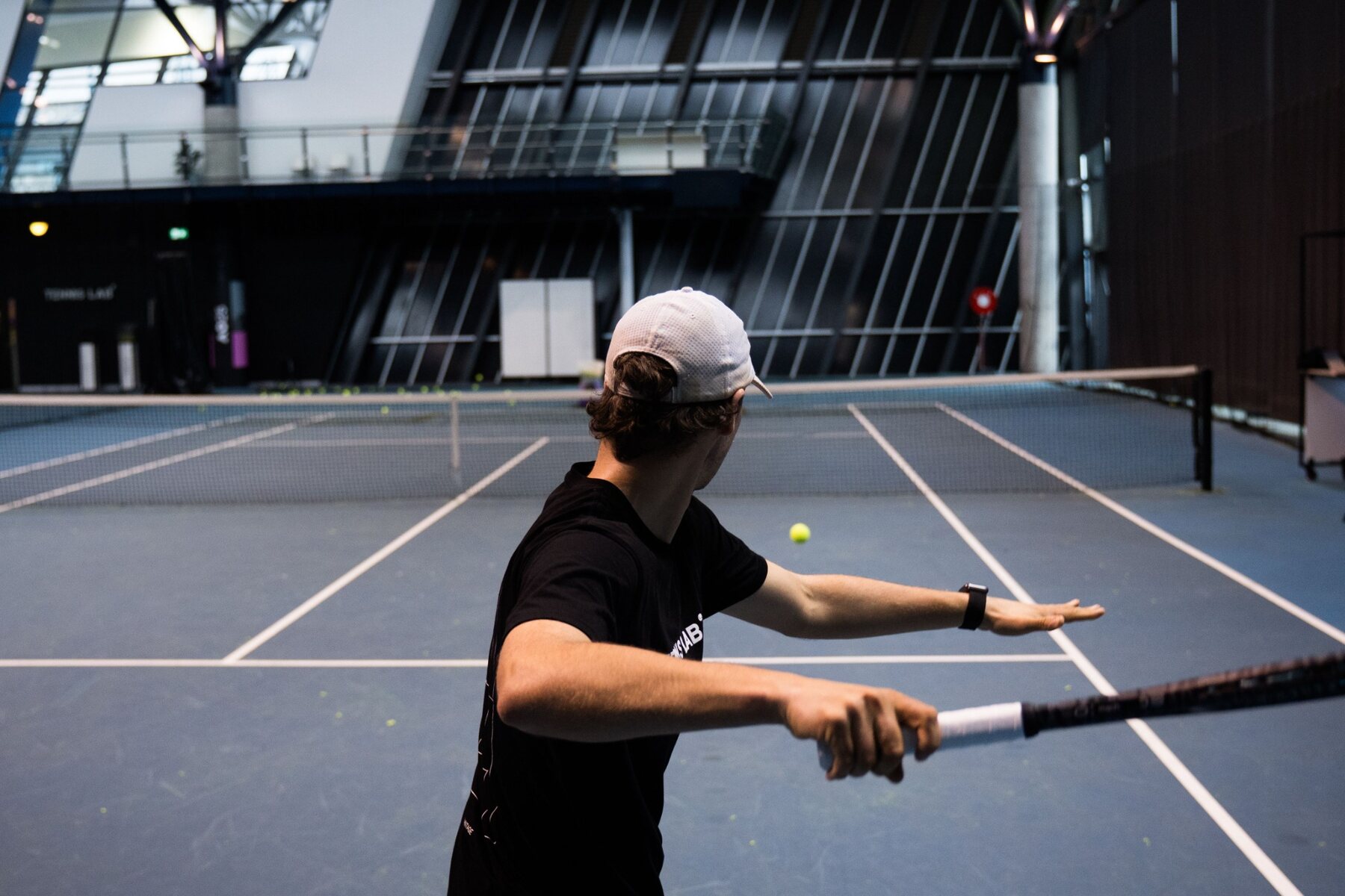 Tennis player practicing on an indoor court